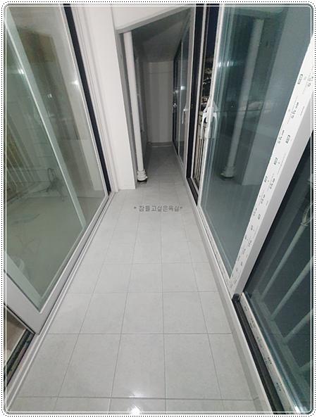 흰색 타일 바닥과 슬라이딩 유리문이 있는 복도