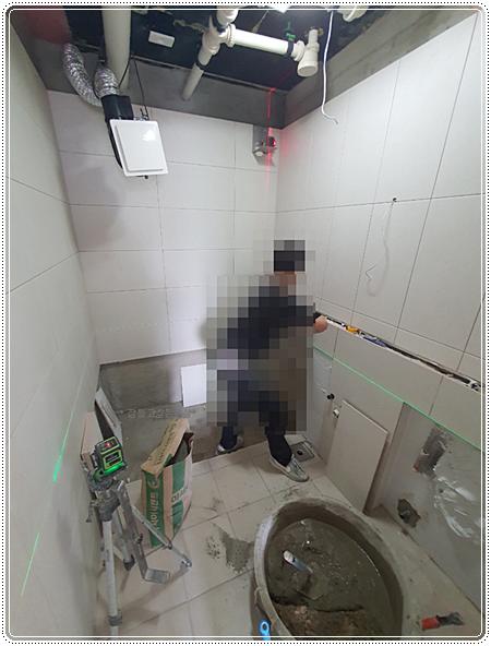 레이저 수평기로 타일 라인을 잡는 작업 현장