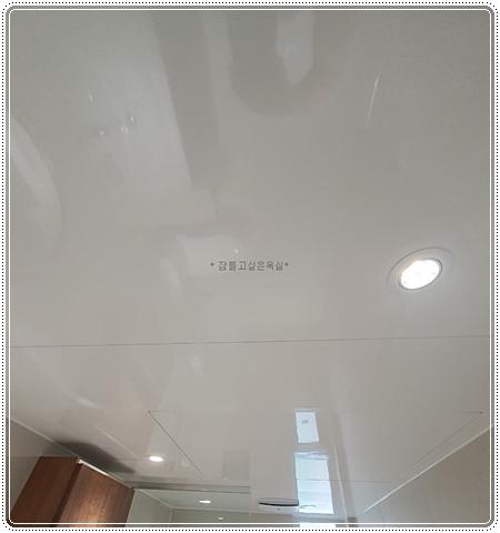 천장 조명과 하단 문이 보이는 실내 모습