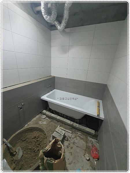 배치 후 수평과 배수를 점검 중인 욕조