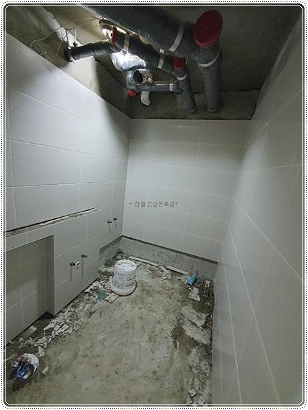 벽타일 시공을 시작한 화이트 톤의 벽면