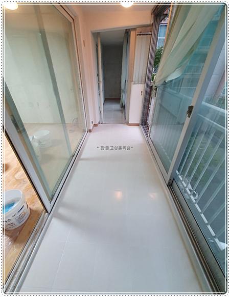 흰색 타일 바닥과 슬라이딩 도어가 있는 복도