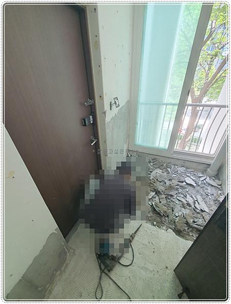 콘크리트 조각이 흩어져 있고 벽면이 벗겨진 현관 철거 모습