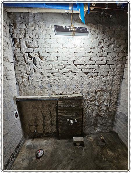 벽돌 벽과 파란 보호 필름 파이프가 노출된 현장