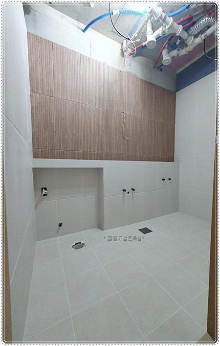 흰색 타일 바닥과 갈색 목재 패널이 설치된 벽면
