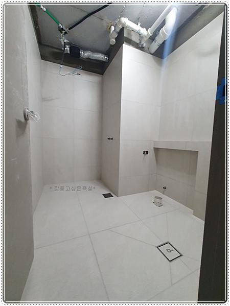 벽과 바닥 타일 시공이 완료된 욕실 내부