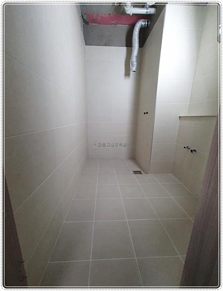 벽 타일과 샤워 설비가 보이는 시공 과정