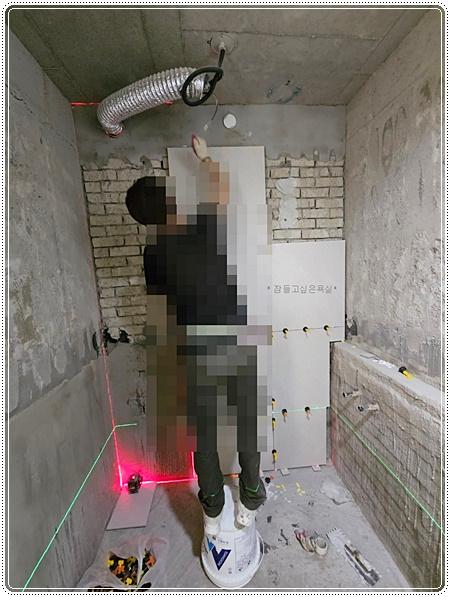 수공구를 사용하여 타일을 부착하는 시공 장면