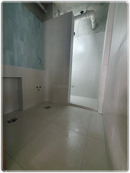 천장 배관과 바닥 배수구가 노출된 철거 후 공간