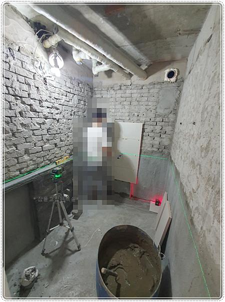 바닥 배수통과 벽면 가이드 라인이 표시된 모습