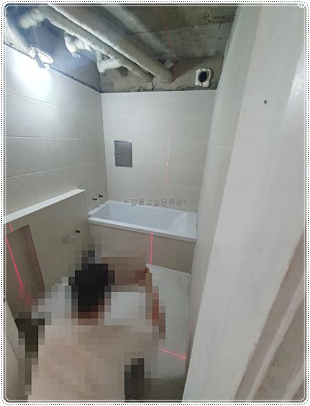 벽면 타일을 부착하고 있는 시공 과정
