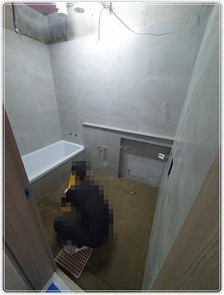 벽면 타일의 수평을 잡으며 시공하는 장면