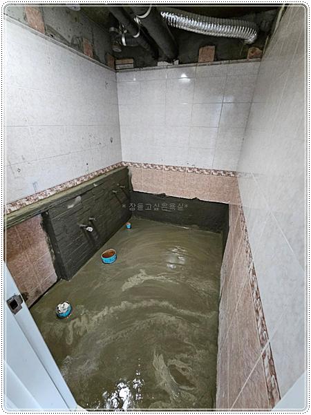 벽면 타일 시공이 진행 중인 욕실 내부