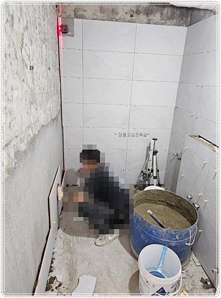 레이저 수준계를 이용해 벽 타일을 부착하는 과정