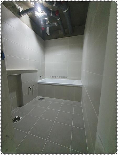 타일 쳐짐 방지를 위해 작업 중인 욕실 벽면