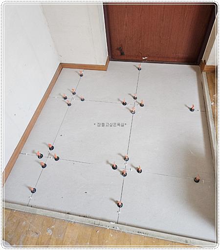 타일 고정 장치가 설치된 바닥 시공 장면