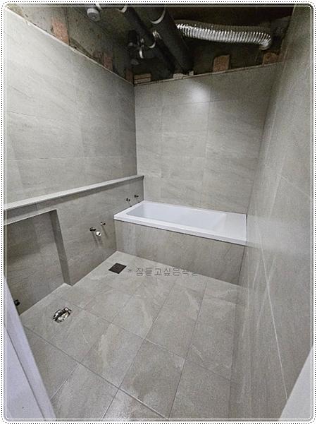 욕조와 주변 설비가 배치된 시공 중인 장면