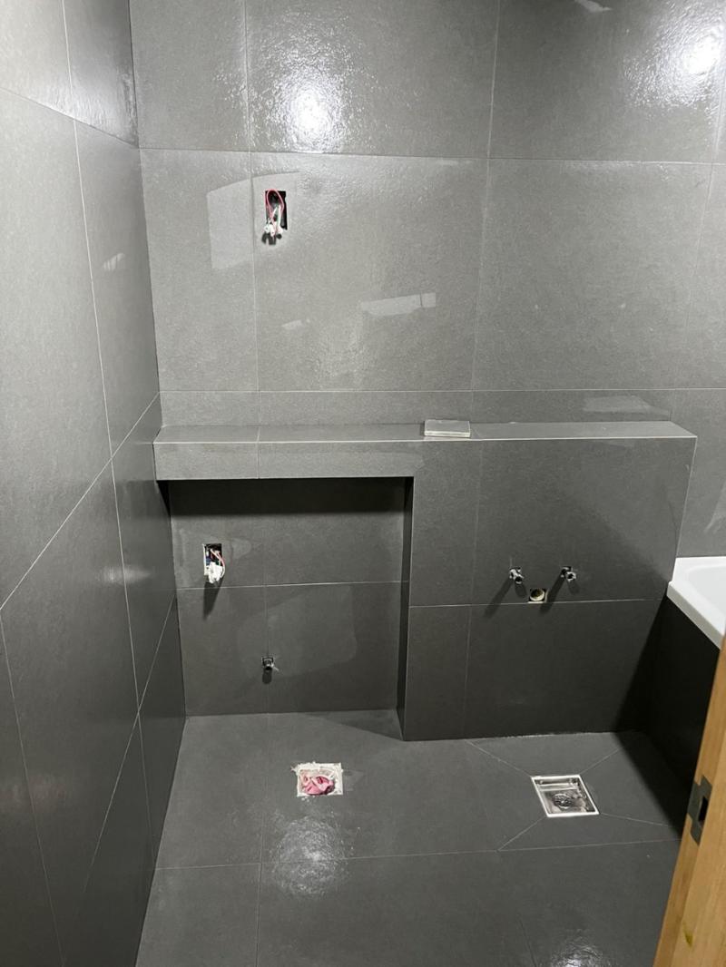 줄눈 라인이 잡혀가는 벽 타일 시공 장면