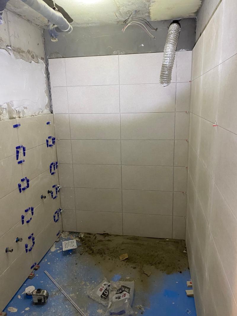 수동 접합 클램프로 타일을 고정하는 장면