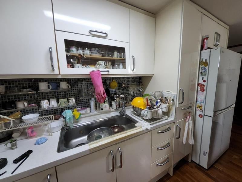 흰색 수납장과 싱크대가 있는 주방 타일 시공 과정
