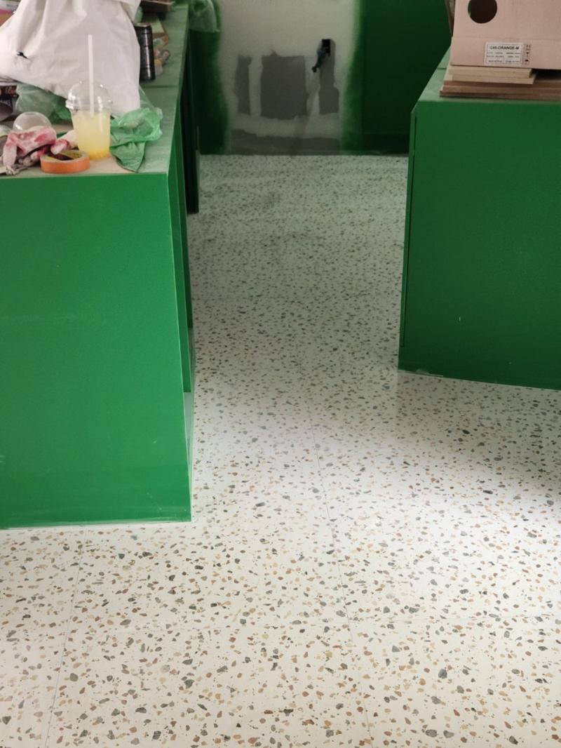 녹색 카운터와 흰색 석재 바닥이 보이는 내부