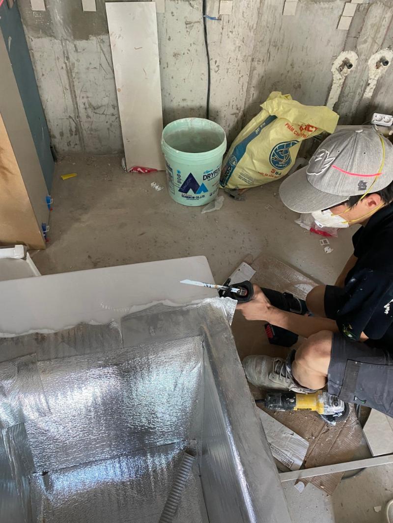 금속 도구로 타일 끝단을 정밀하게 가공하는 작업자