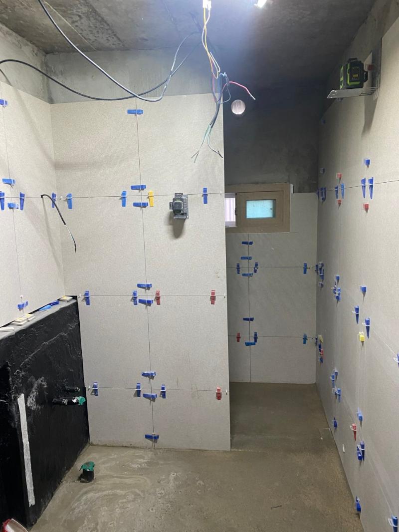 컬러 클립으로 고정된 벽면 타일 시공 과정
