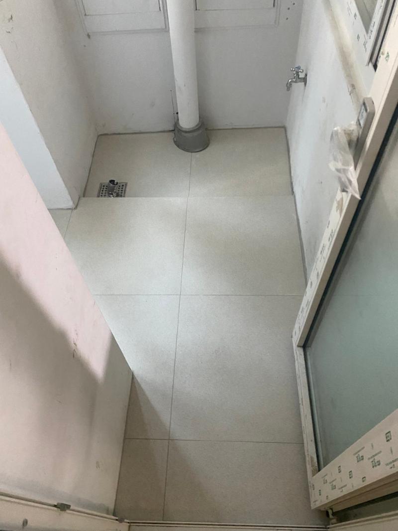 배수구와 수도꼭지가 설치된 좁은 타일 공간