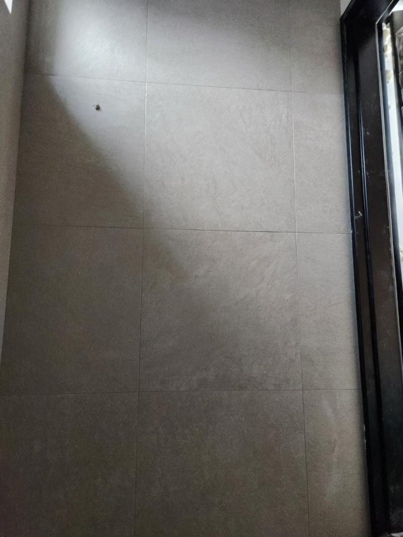검은색 도어 프레임과 맞닿은 대형 타일 벽면