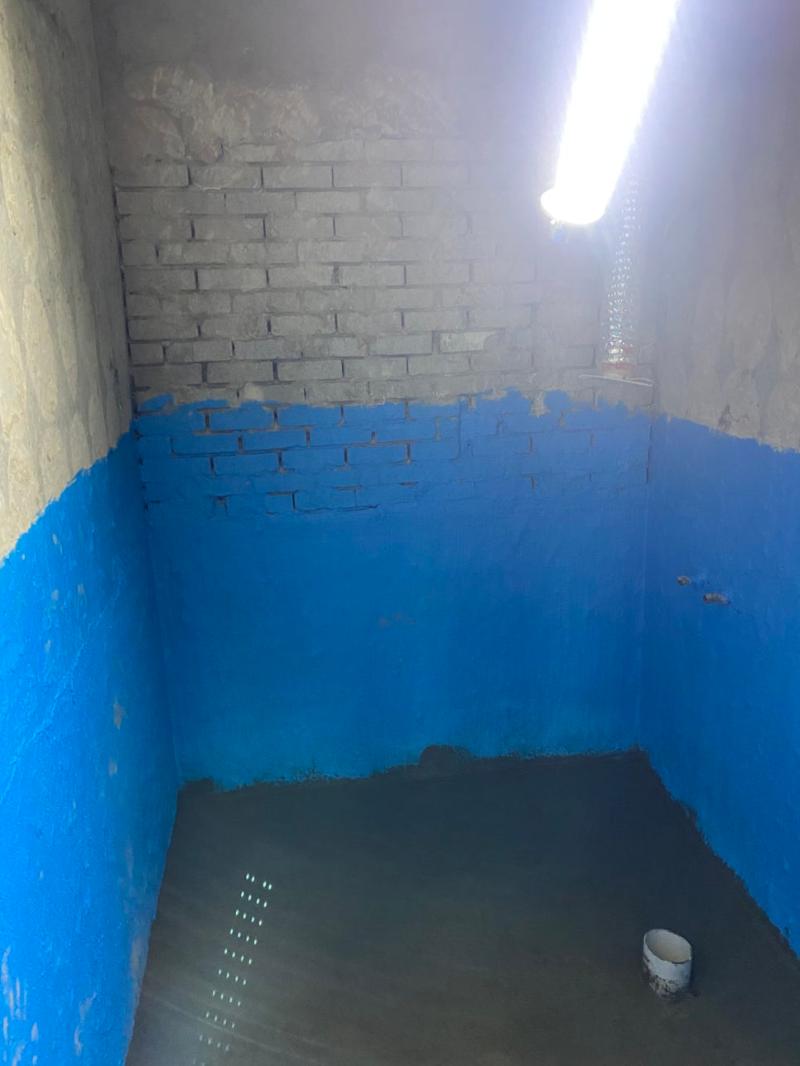 파란색 방수 도료가 도포된 벽면과 흙바닥