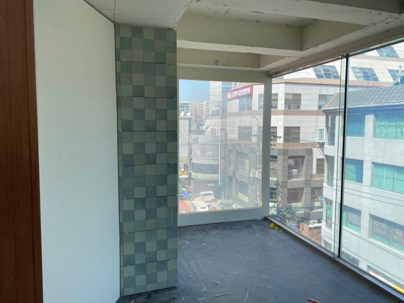 검은색 콘크리트 바닥과 회색 타일 벽이 있는 발코니