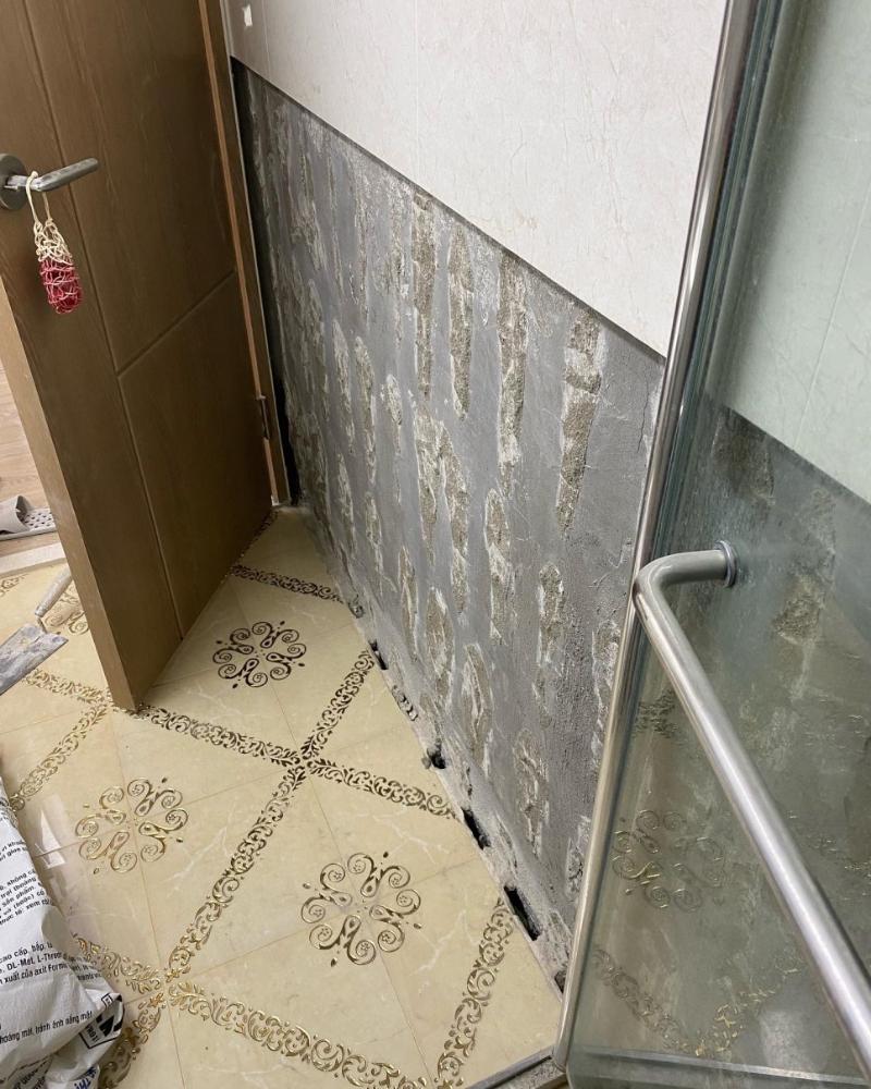 타일 마감이 제거된 현관 벽면과 바닥