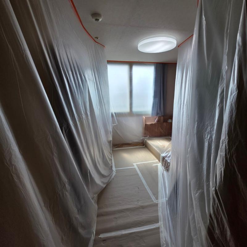 투명 플라스틱 시트로 보양된 복도와 목재 마루 바닥