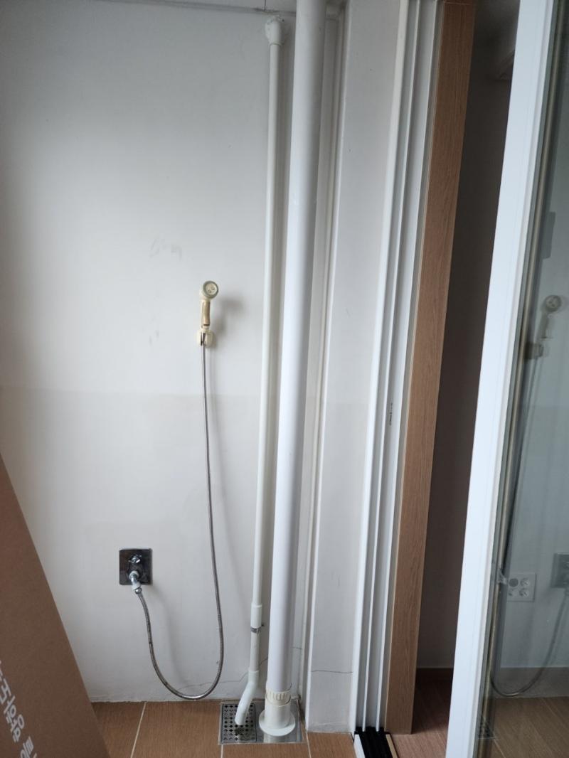 수도관과 전기 소켓 호스가 보이는 벽면