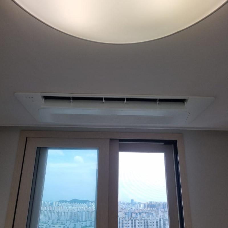원형 조명과 공기순환기가 설치된 천장과 창호 유리 패널