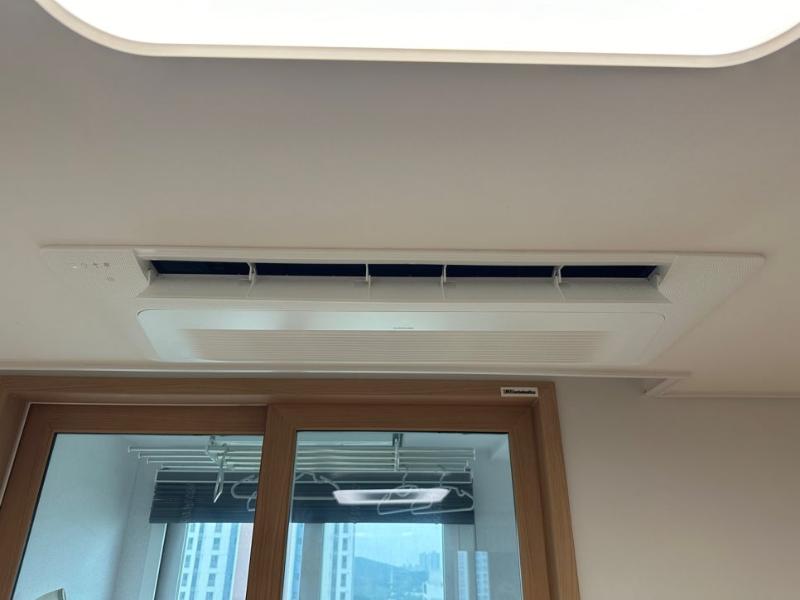천장 에어컨과 목재 프레임 창문이 보이는 실내