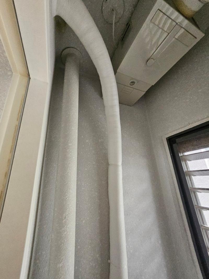 흰색 보온재로 마감된 세로 배관과 조절 장치