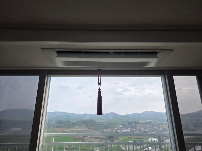 외부 풍경이 보이는 발코니 창문 위 에어컨