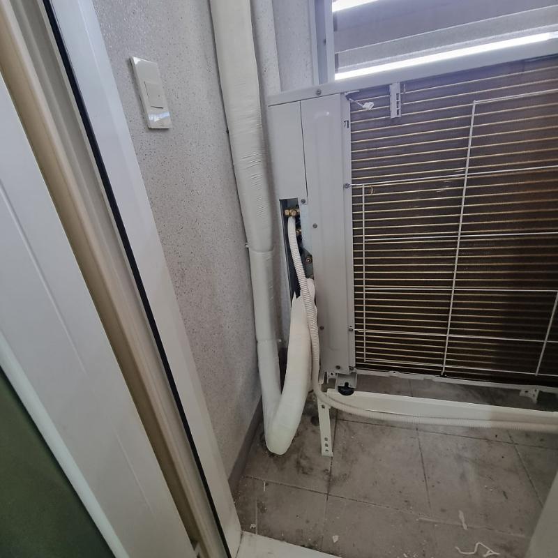 벽면에 설치된 에어컨 외부 유닛과 흰색 배관