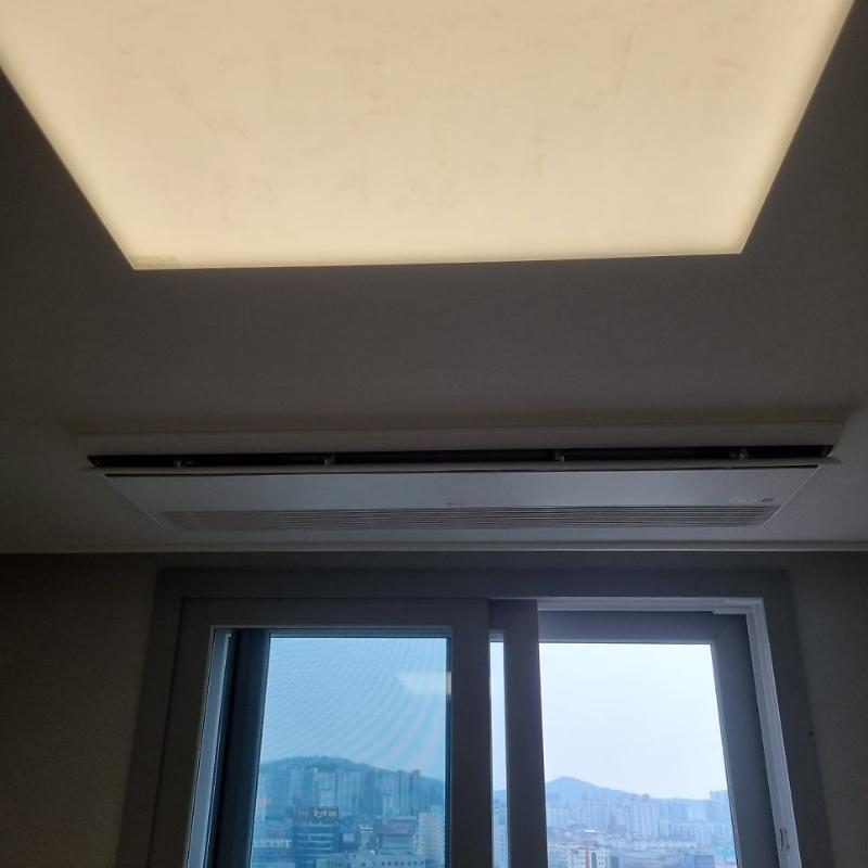 사각형 조명과 벽면 에어컨이 설치된 실내