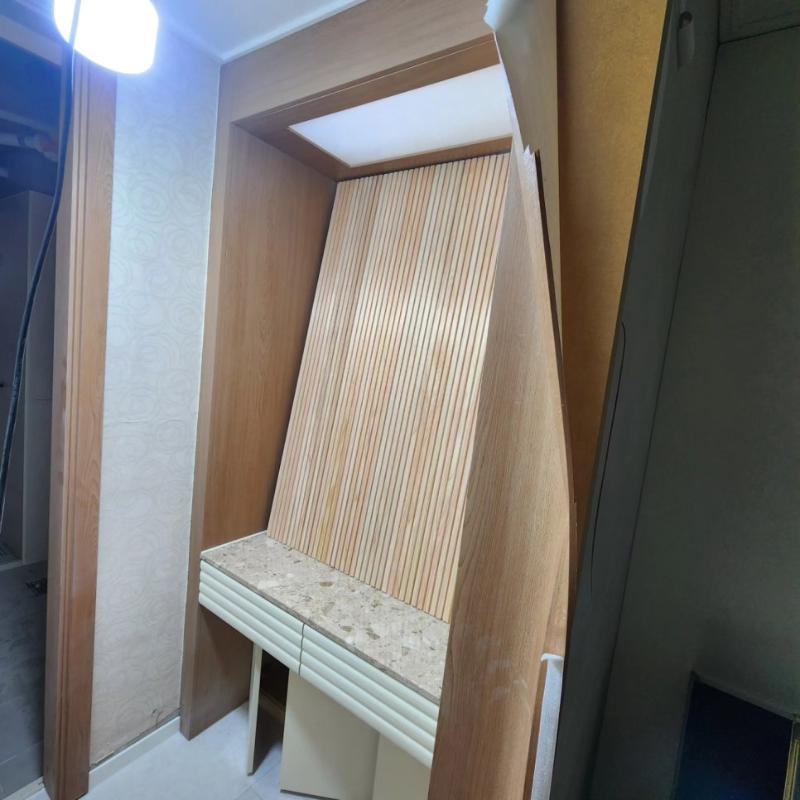 목재 패널과 석재 상판이 만나는 벽면