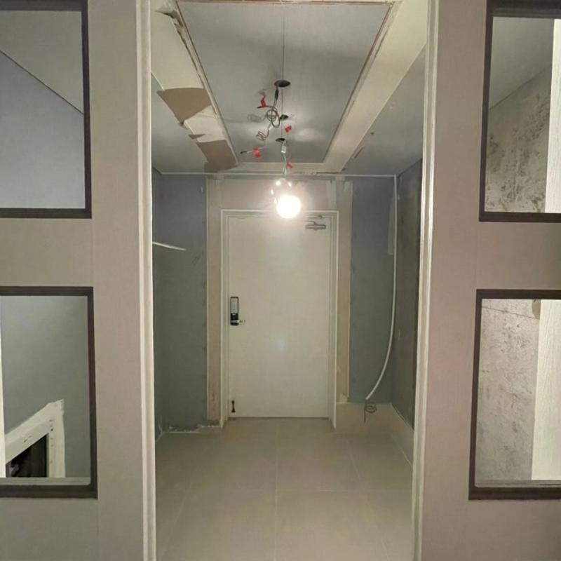 전선이 노출된 복도 공간의 도어와 벽면 마감 상태