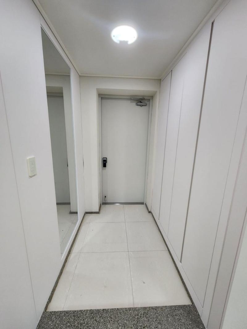 흰색 타일 바닥과 도어들이 배치된 복도 시공 중