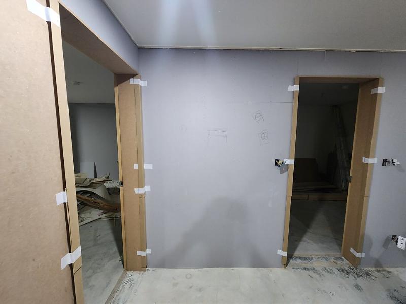 흰색 페인트 벽면에 목재 프레임이 고정된 모습