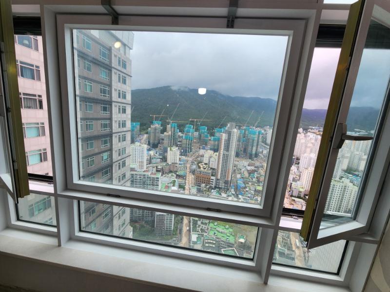 창밖 건물들이 보이는 열린 창호의 근접 모습