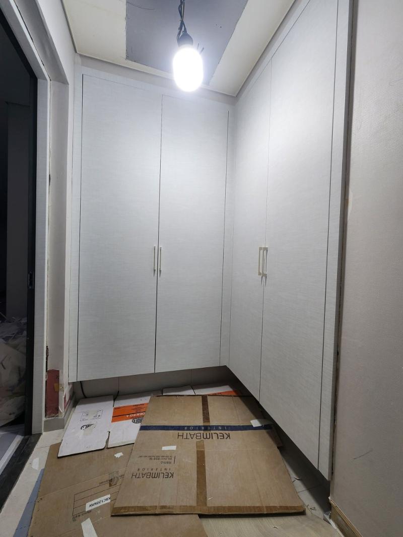흰색 수납장이 설치된 복도 작업 현장