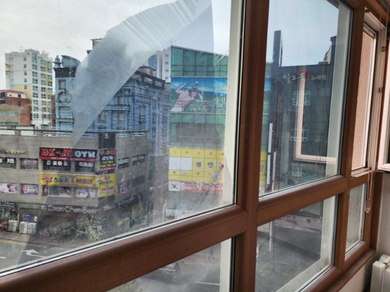 도시 풍경이 반사된 창호 프레임 근접 모습