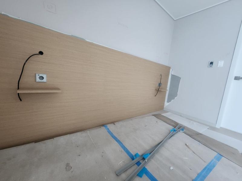 목재 패널과 전기 소켓이 설치된 벽면 작업 중