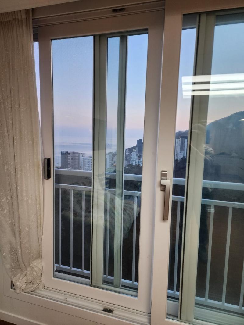 해변 뷰가 보이는 창호 프레임의 화이트 마감