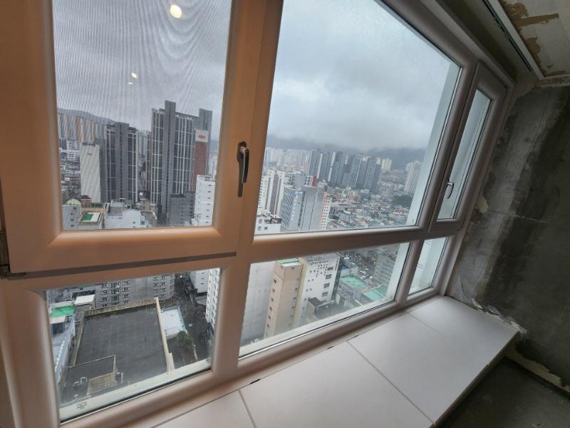 도시 풍경이 보이는 창호와 미완성 상태의 내부 벽면